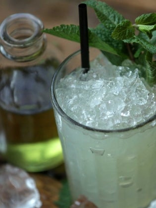 Absinthe FrappÃ© on wooden table with crushed ice