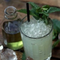 Absinthe FrappÃ© on wooden table with crushed ice