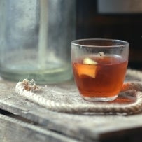 Sazerac cocktail on wooden box with rope and old glass bottle